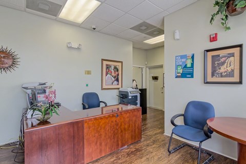 a doctors office with a wooden reception desk and blue chairs