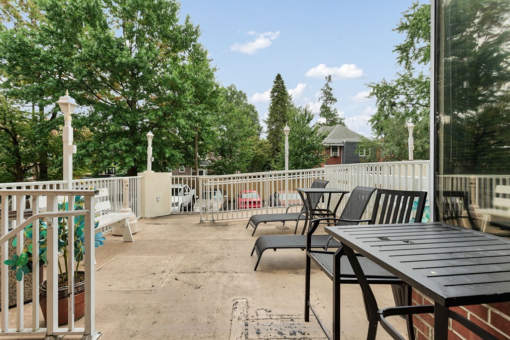 a patio with tables and chairs and a fence