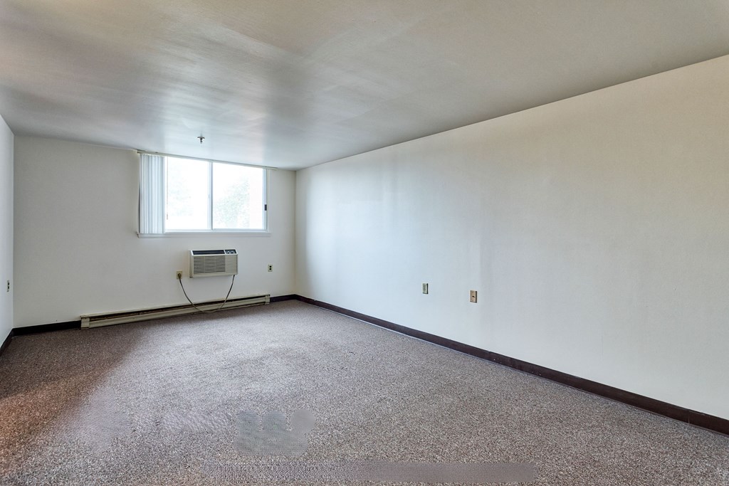 an empty room with white walls and a window