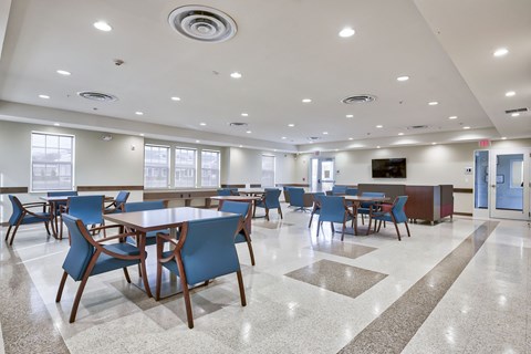 a large dining room with tables and chairs and a television