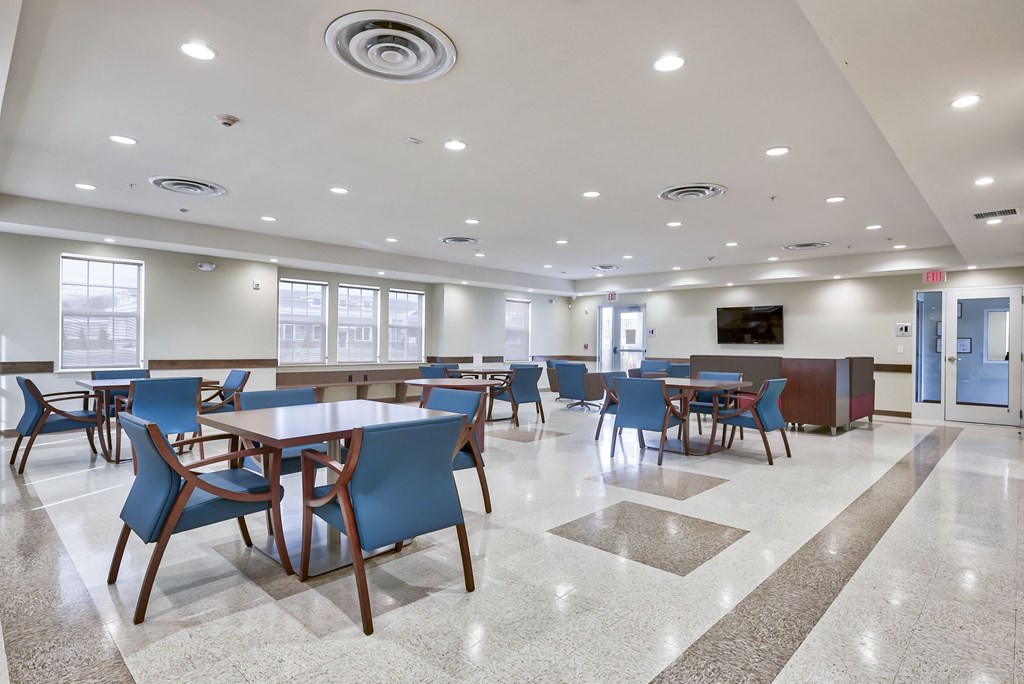 a large dining room with tables and chairs and a television