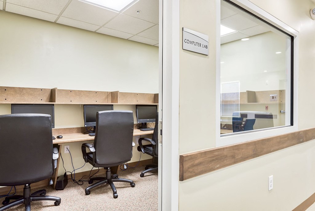 an office with desks and chairs and a window