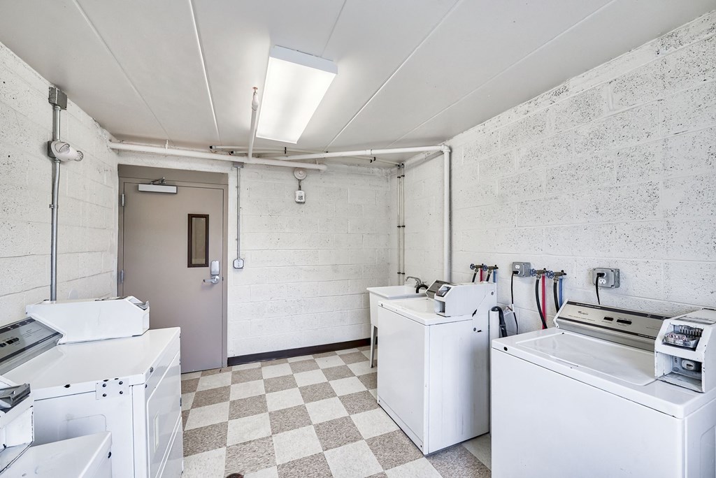a kitchen with white appliances and a checkered floor