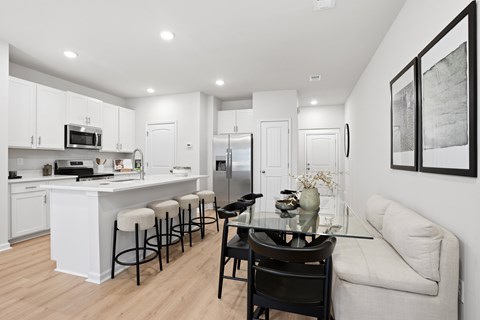 A modern kitchen with white cabinets and a bar area.
