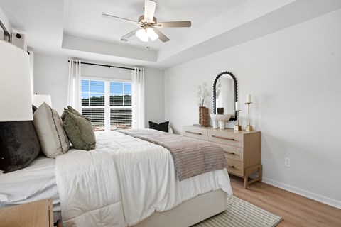 A bedroom with a bed, nightstand, and window.