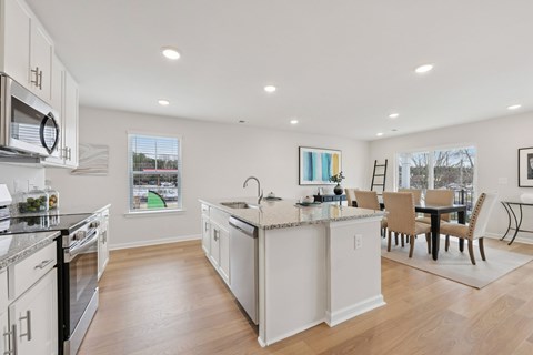 A modern kitchen with white cabinets and a large island.