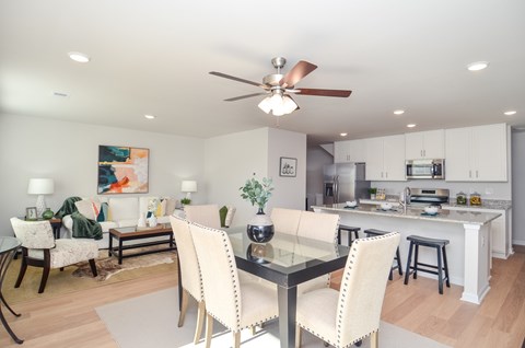 A modern dining room with a glass table and chairs.