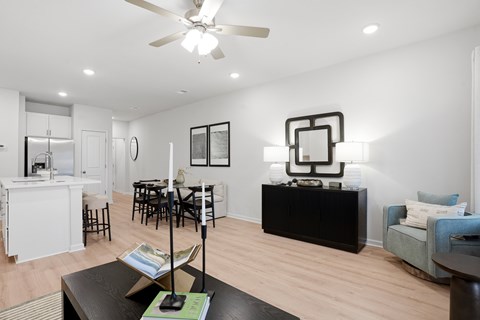 A living room with a black coffee table and a white ceiling fan.