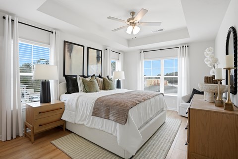A bedroom with a large bed and a ceiling fan.