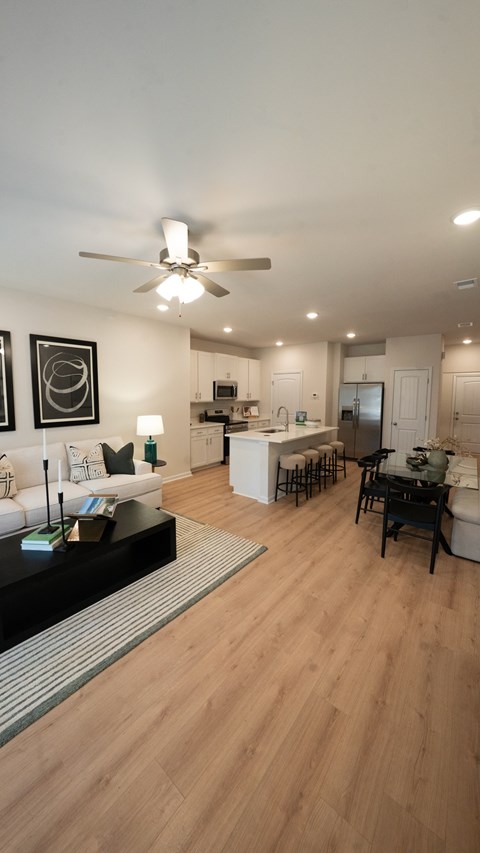 A modern living room with a white sofa and a wooden floor.