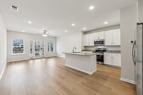 A kitchen with white cabinets and a refrigerator.
