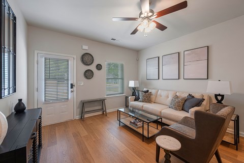 A living room with a white couch, a coffee table, and a ceiling fan.