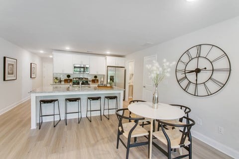 a white kitchen with a large clock on the wall