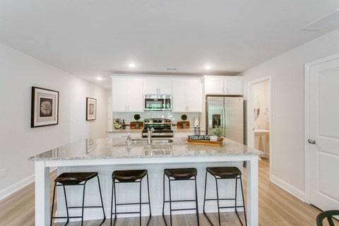 a kitchen with a marble counter top and three bar stools