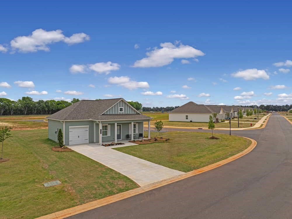 A house with a grey roof and a driveway in front of it.