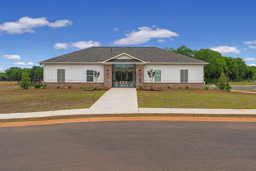 A white house with a grey roof and a brown front door.