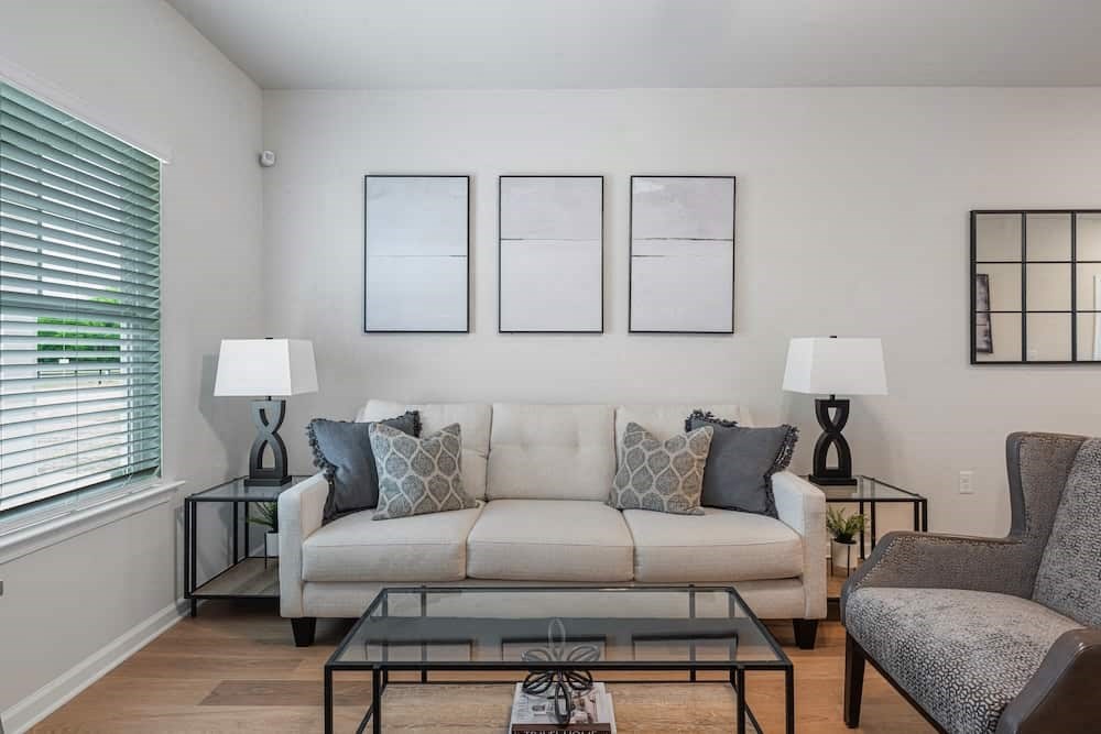 A living room with a white couch, two lamps, and a coffee table.