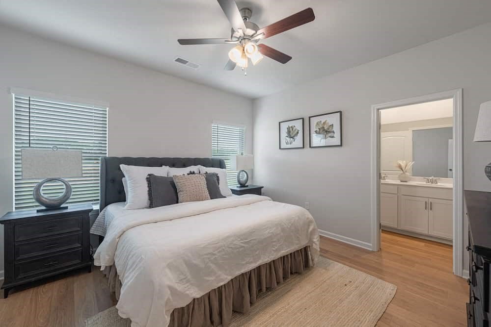 A bedroom with a large bed and a ceiling fan.