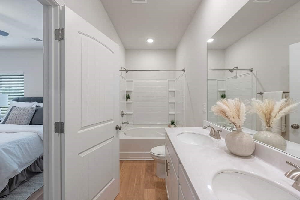A white bathroom with a white sink and a white toilet.