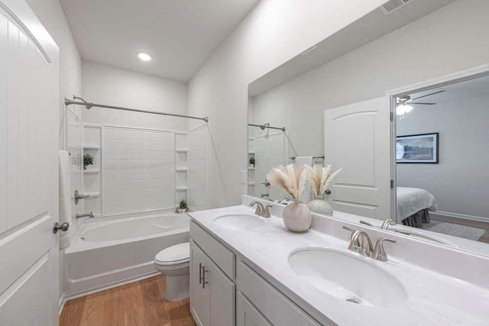 A white bathroom with a white tub and sink.