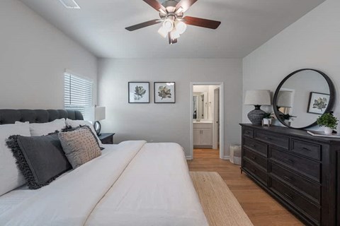 A bedroom with a large bed and a dresser with a mirror.