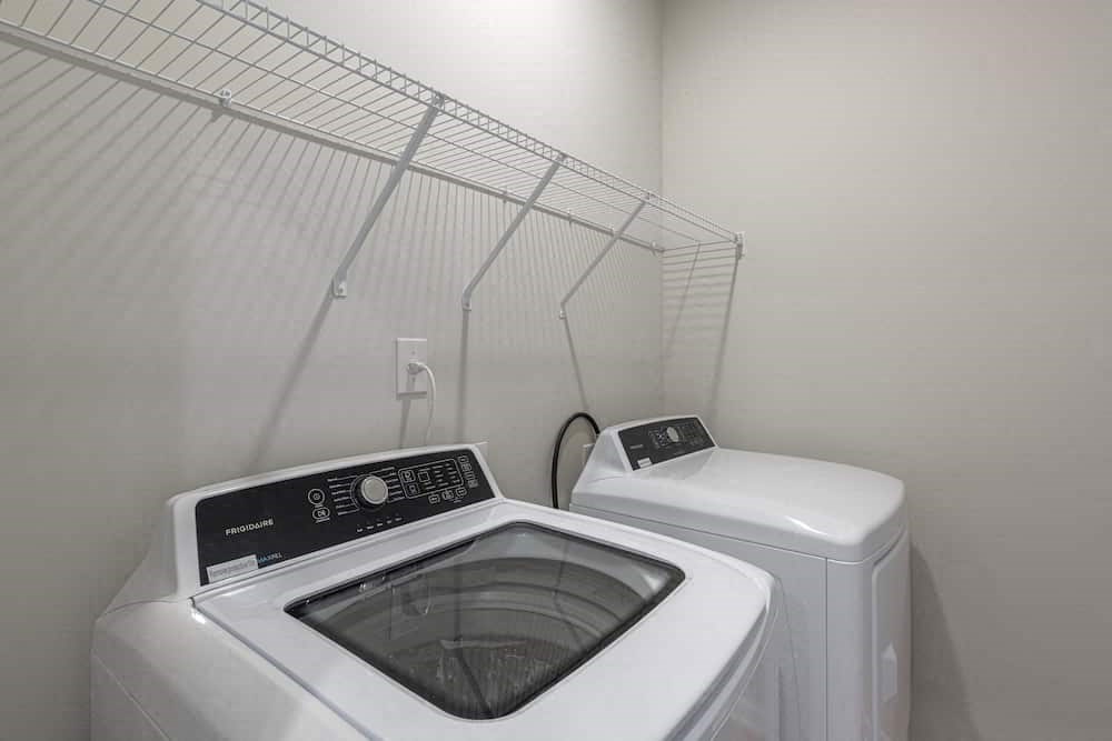 A white washing machine and dryer in a small laundry room.
