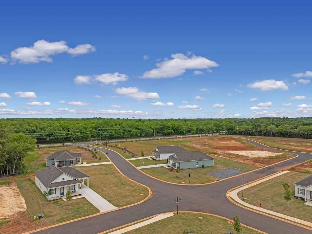 A residential area with houses and a curved road.