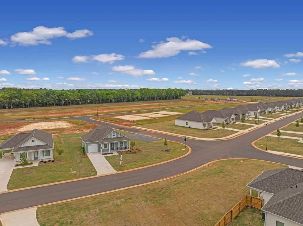 A suburban neighborhood with houses and a large open field.