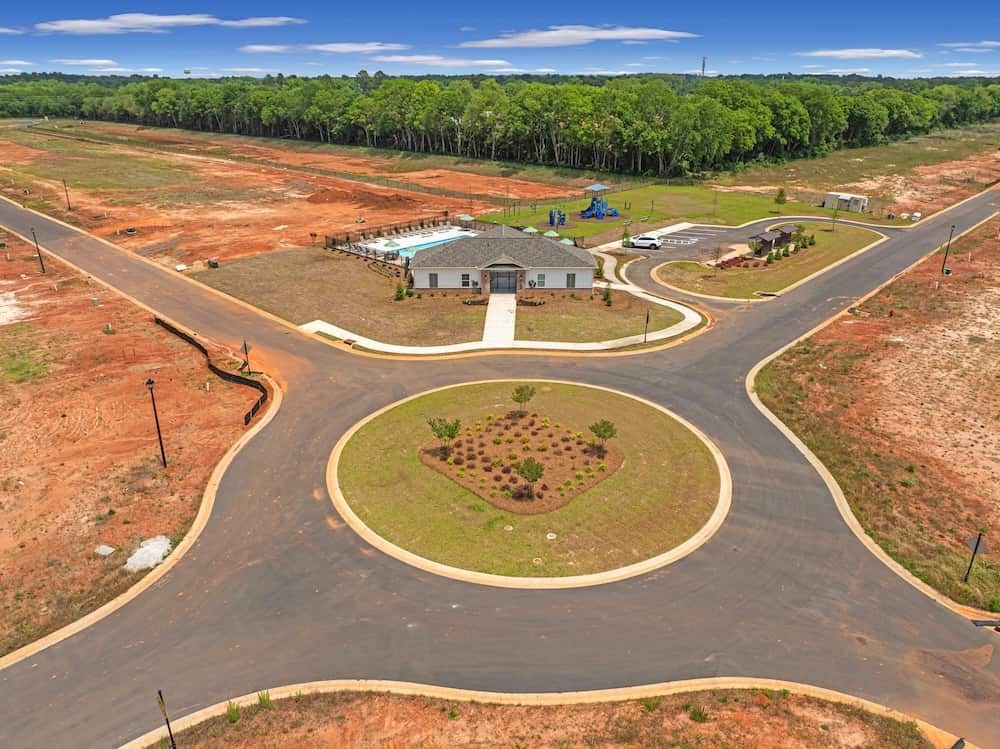 A roundabout with a building and trees in the background.