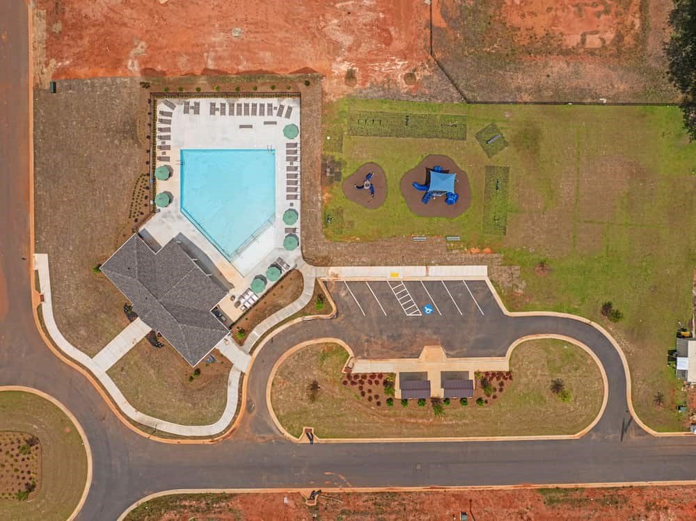 A large building with a pool in the middle of a grassy area.