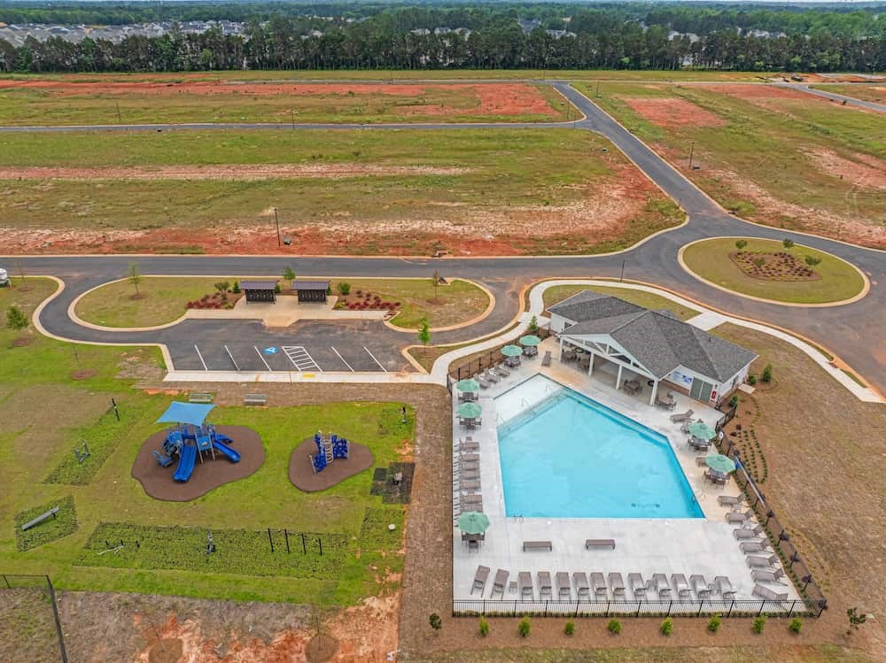 A large outdoor swimming pool with a small building next to it.