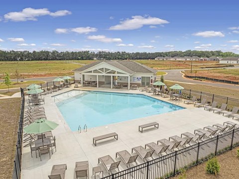 a swimming pool with chairs around it and a building