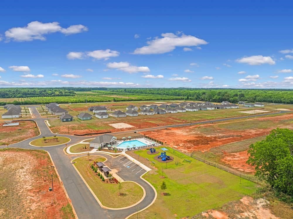 A bird's eye view of a residential area with a swimming pool and a playground.