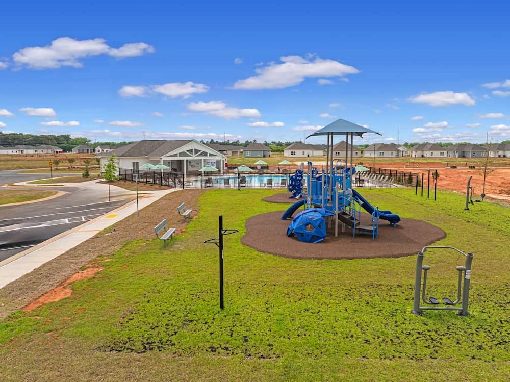 A playground with a blue slide and a green lawn.