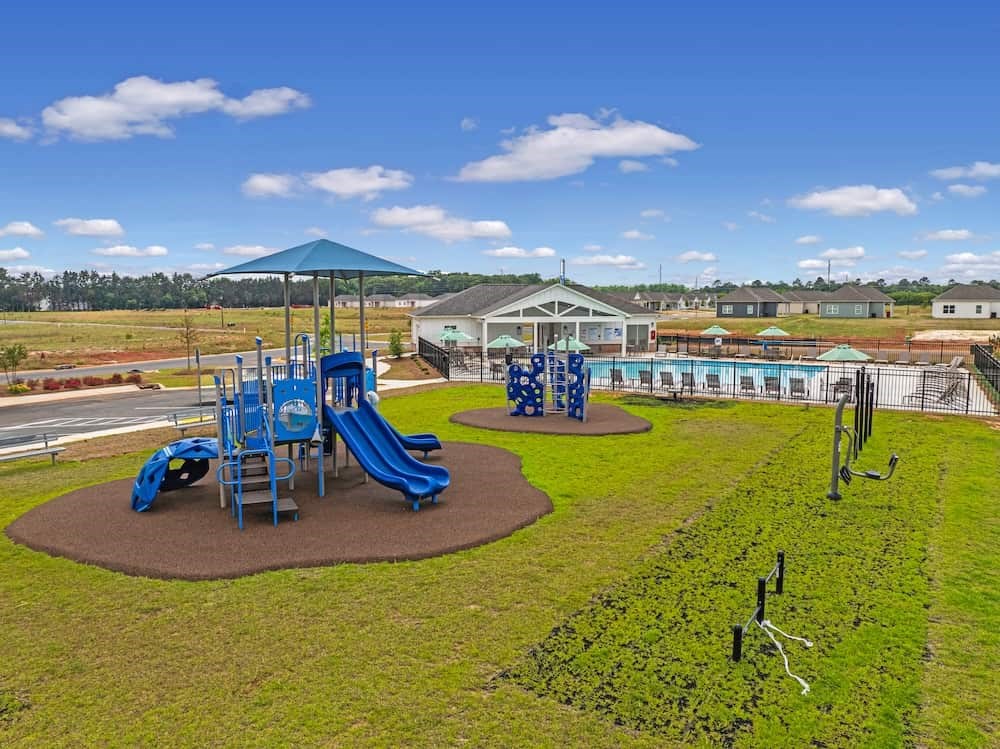 A playground with a blue slide and a green canopy.