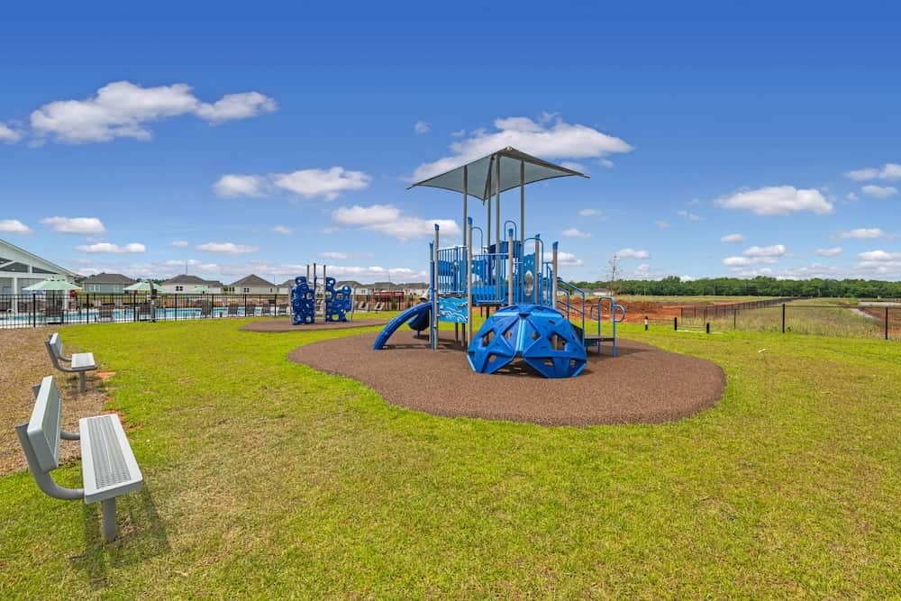 A playground with a blue slide and a roundabout.