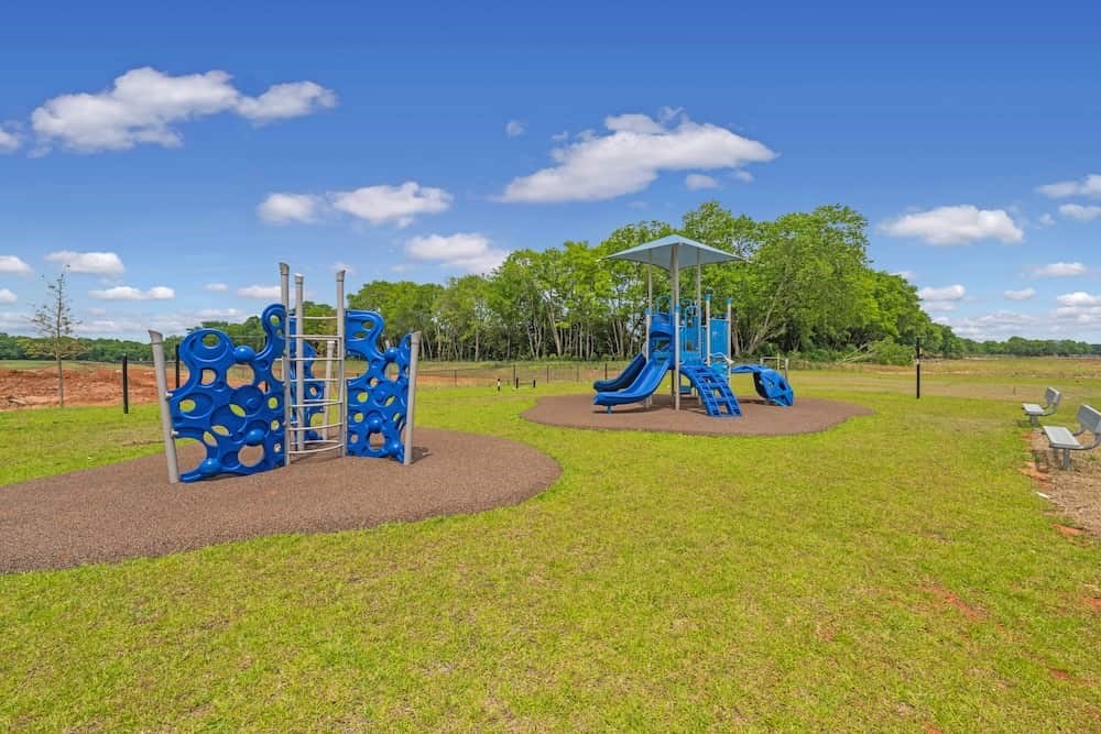 A playground with a blue slide and a climbing structure.