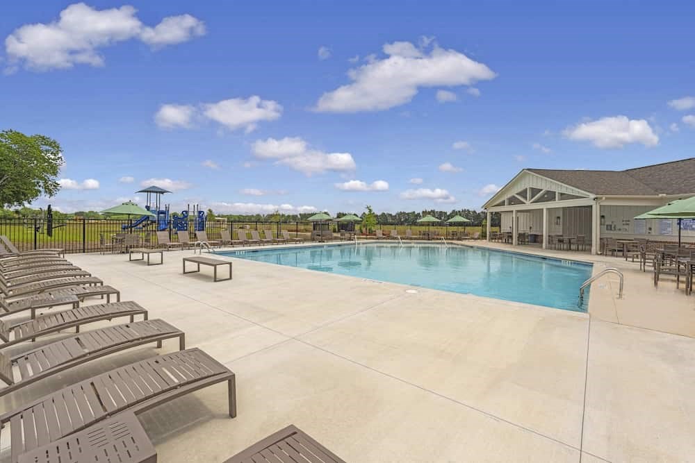 A large outdoor swimming pool surrounded by sun loungers.