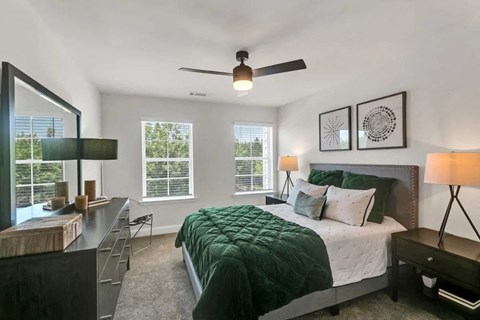 a bedroom with a bed and a ceiling fan