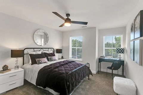 a bedroom with a bed and a ceiling fan