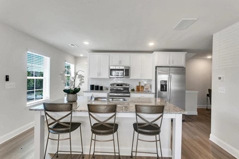 a kitchen with an island with three stools