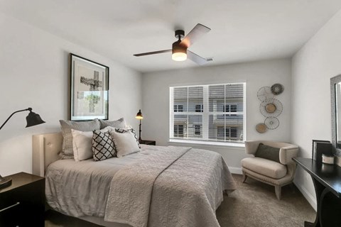 a bedroom with a bed and a ceiling fan