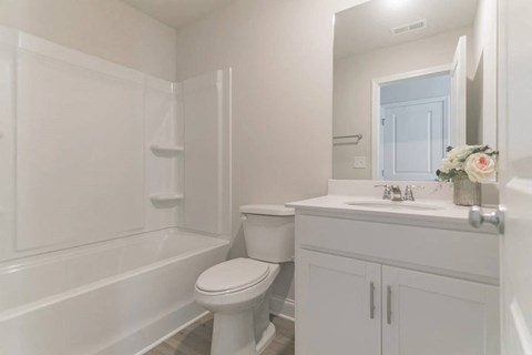 a white bathroom with a toilet and a sink