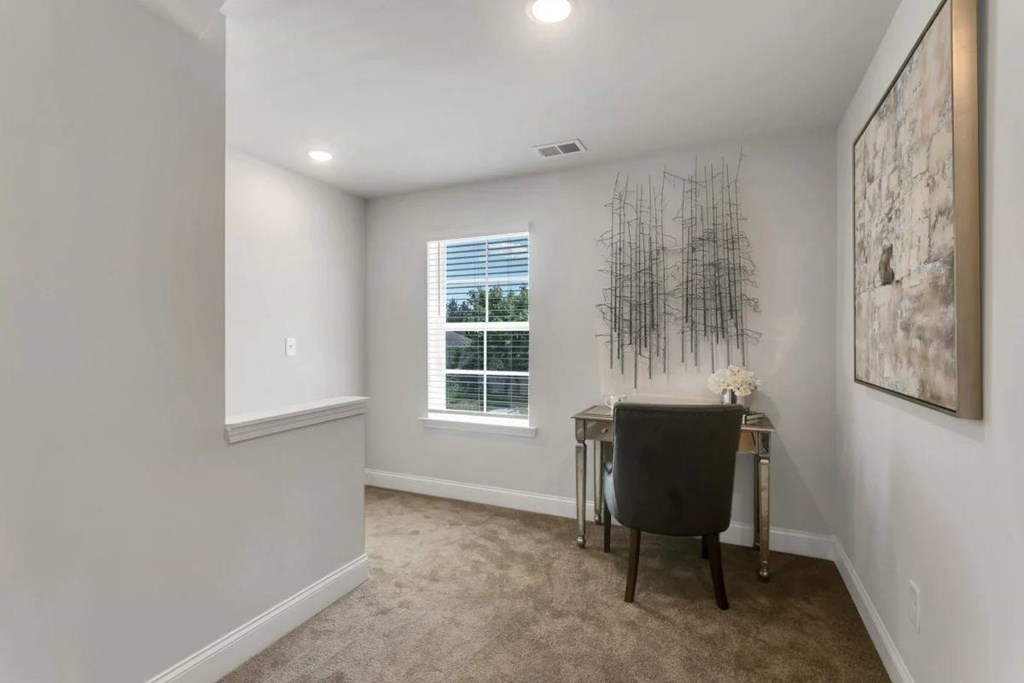 A room with a desk and a chair in front of a window.