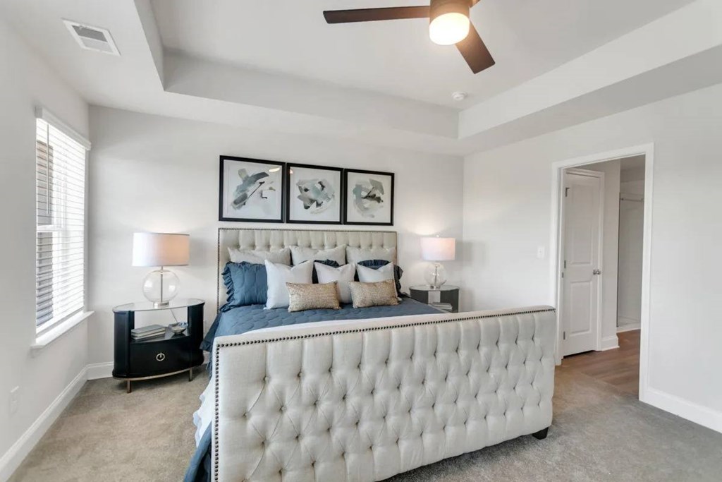 A bedroom with a large bed and a ceiling fan.