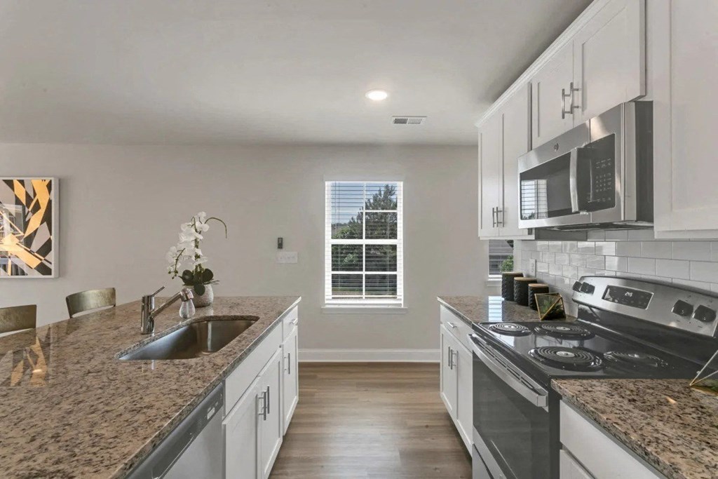 A kitchen with granite countertops and stainless steel appliances.