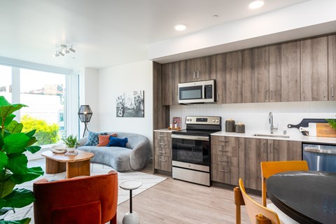 A modern kitchen with wooden cabinets and a microwave above the oven.