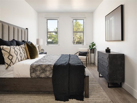 A bedroom with a large bed and a chair.