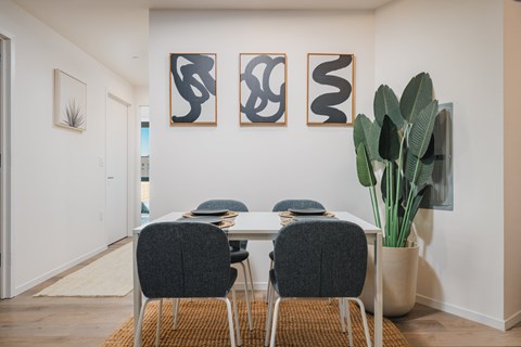 A dining room with a table and chairs.