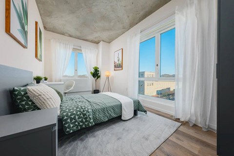 A bedroom with a large bed and a view of the city.